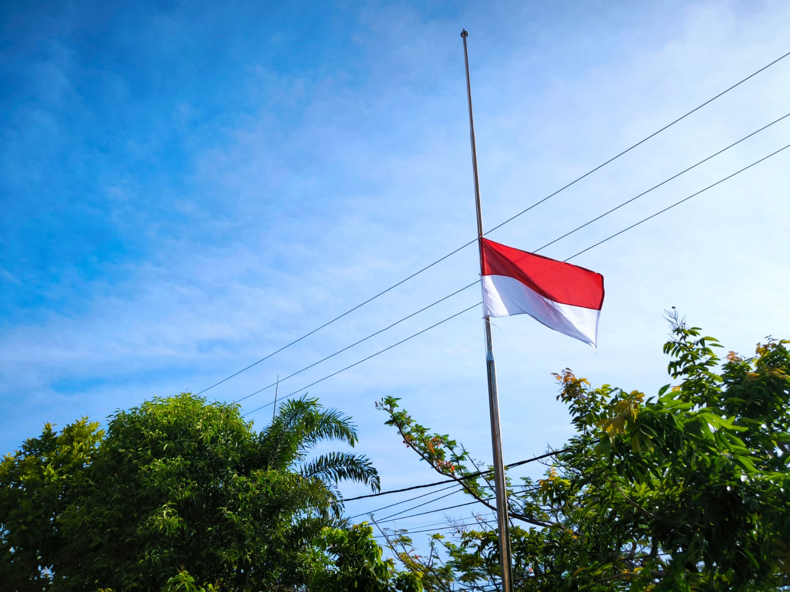 Ilustrasi pengibaran bendera setengah tiang untuk Hari Kesaktian Pancasila.