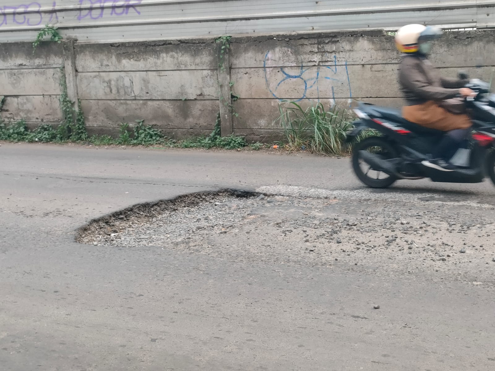 Kondisi jalan menuju Stasiun Depok Baru, Kota Depok, yang rusak dan berlubang.