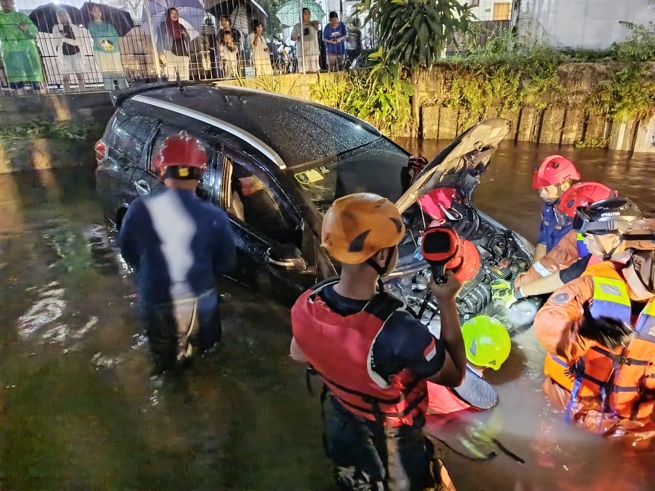Evakuasi mobil terperosok sungai akibat terseret banjir di Jalan Balikpapan, Cimanggis, Kota Depok.