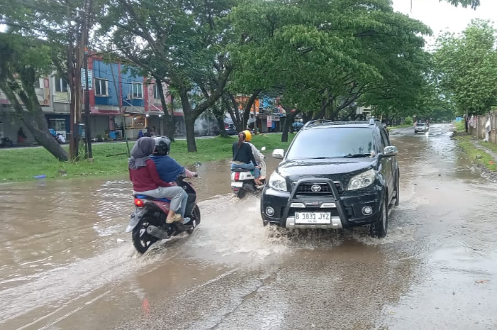 Hujan deras memicu genangan air di Jalan Raya Cicangkal, Desa Sukamulya, Rumpin, Kabupaten Bogor.