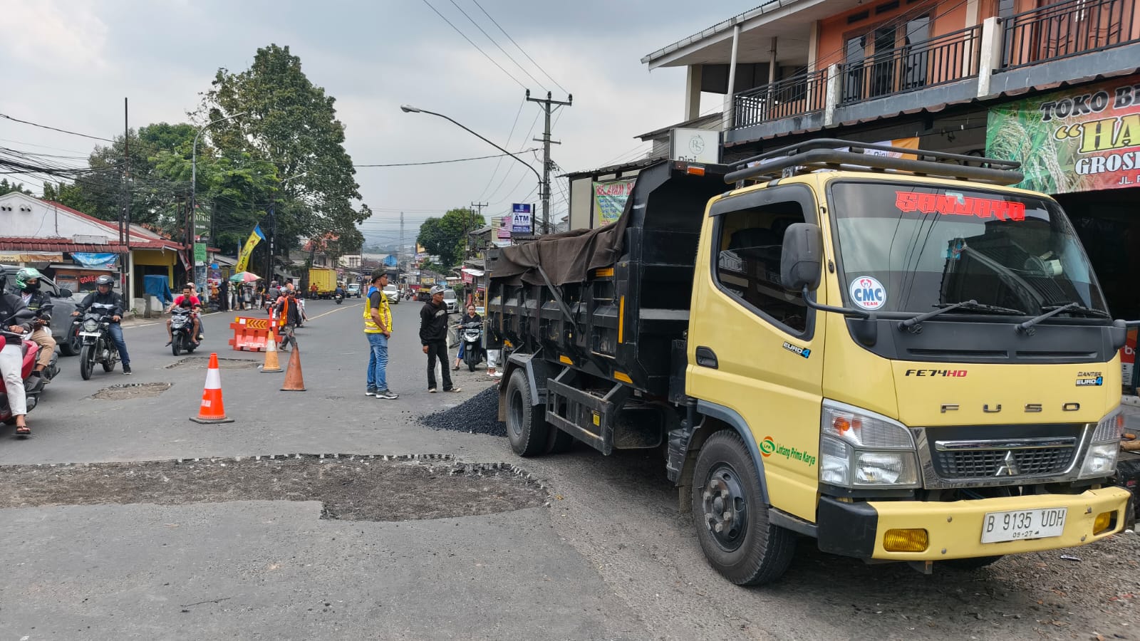 PT Tirta Investama - AQUA wilayah Bogor, melakukan perbaikan jalan nasional di jalur Jalan Raya Bogor Sukabumi dengan titik area pertigaan Cigombong, Kabupaten Bogor.