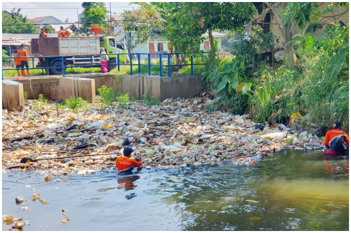 Petugas DLH saat membersihkan tumpukan sampah di irigasi Setu Cikaret, Cibinong, Kabupaten Bogor Selasa 14 Oktober 2025.