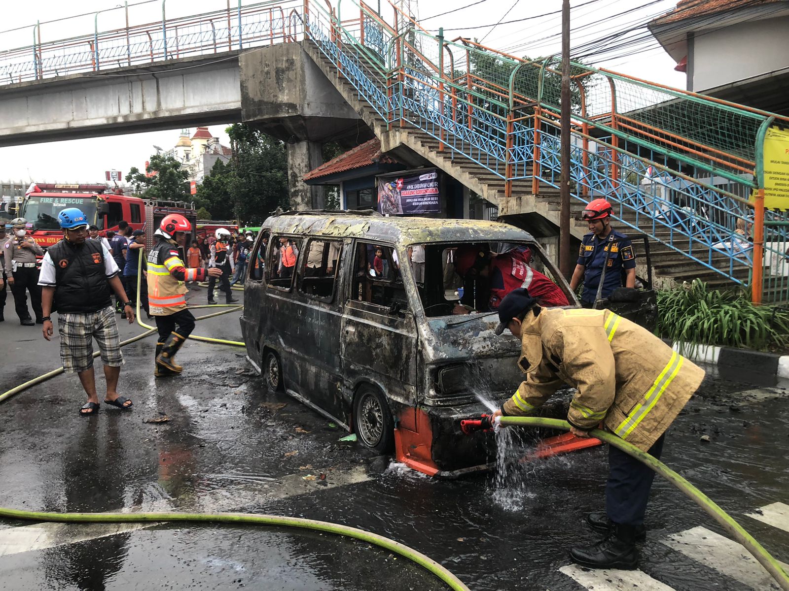 Proses pendinginan angkot terbakar di Jalan Kapten Muslihat, Kota Bogor, Rabu 15 Oktober 2025.