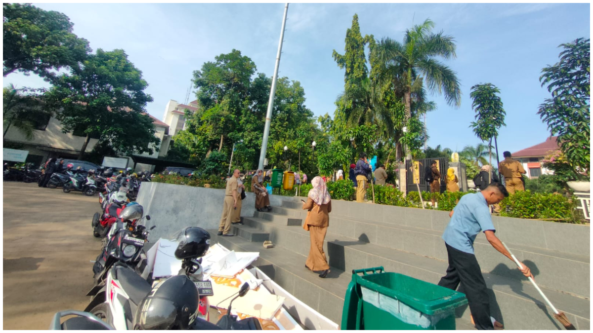 Sejumlah ASN dan pegawai Pemkot Depok menunggu di depan gerbang Balai Kota Depok lantaran terlambat mengikuti apel pagi Senin 27 Oktober 2025.