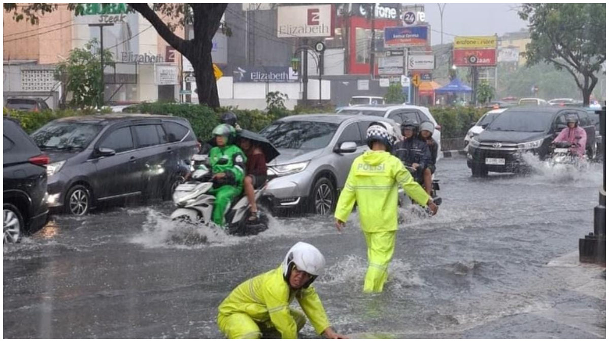 Sejumlah petugas Satlantas Polres Metro Depok membersihan saluran buangan air di Jalan Margonda yang tersumbat.