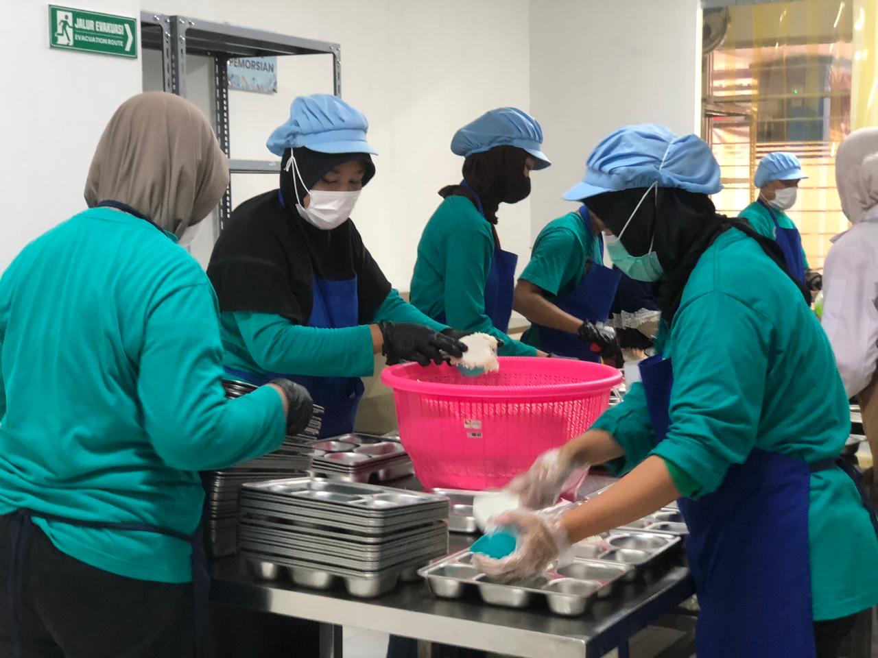 Pekerja yang tengah memproduksi menu MBG di SPPG Yasmin.