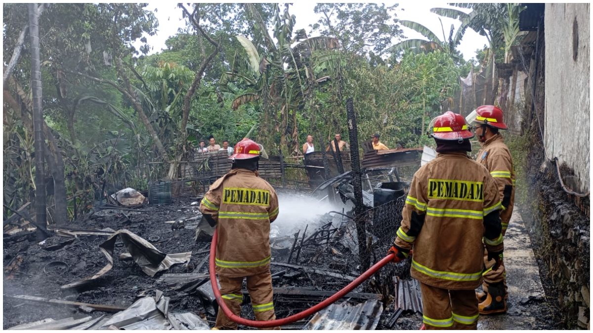 Petugas Damkar Kota Depok saat melakukan proses pemadaman lapak rongsokan yang terbakar.