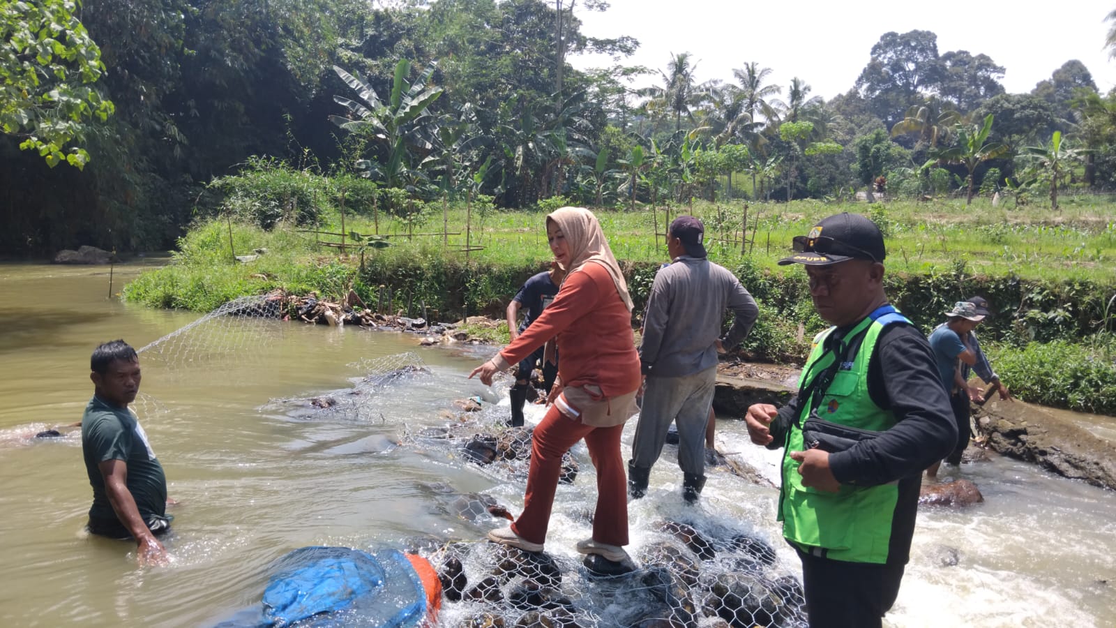 Warga bergotong royong memasang bronjong kawat di Bendungan Sesepan, Desa Karacak, Kecamatan Leuwiliang, Kabupaten Bogor, yang jebol akibat bencana alam.