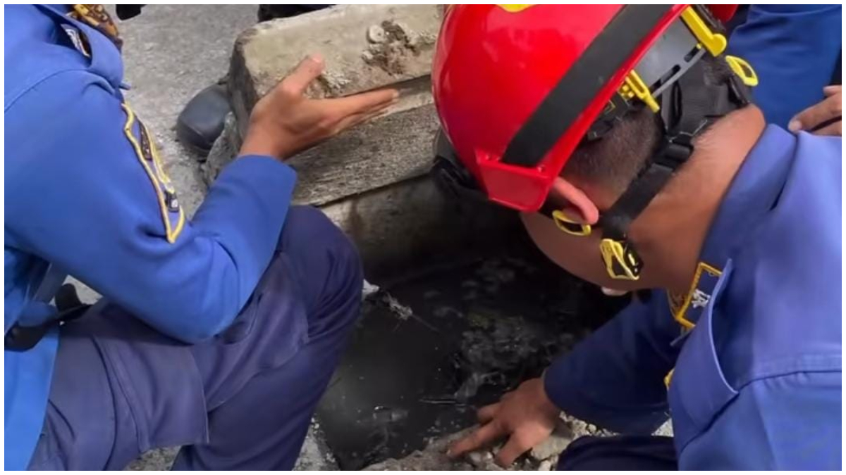 Petugas Rescue Dinas Damkar Kabupaten Bogor mengevakuasi kunci motor milik warga yang terjatuh ke selokan di Pura Bojonggede, Kecamatan Tajurhalang.