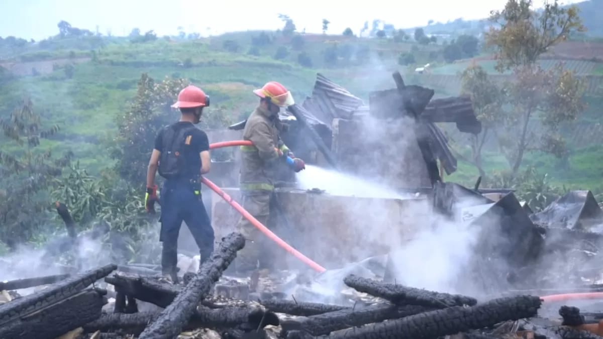 Petugas Damkar Sektor Cariu padamkan api yang lalap dua unit rumah di Desa Sukawangi, Kecamatan Sukamakmur, Kabupaten Bogor.