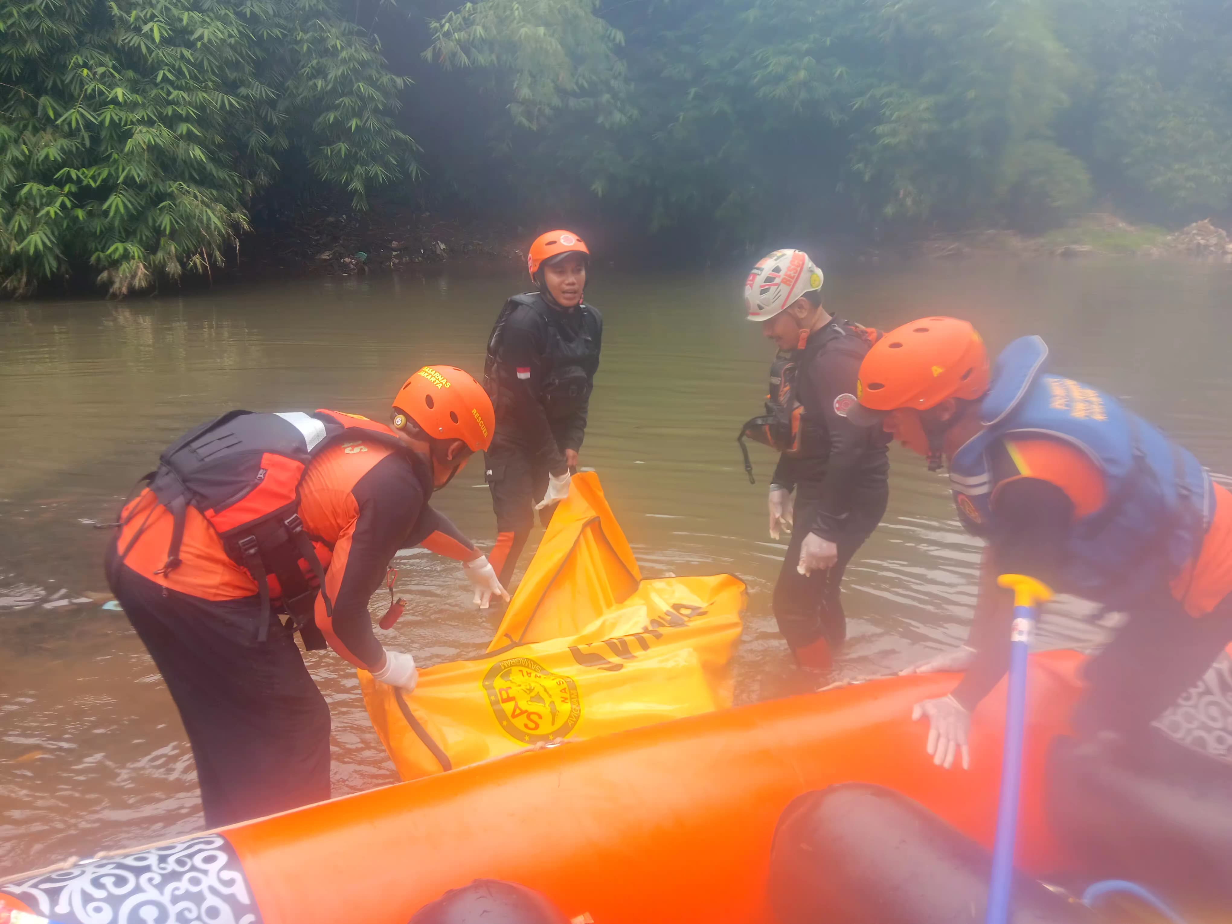 Petugas mengevakuasi jasad pria paruh baya yang ditemukan mengambang di Sungai Ciliwung, Kelurahan Ratujaya, Kota Depok.