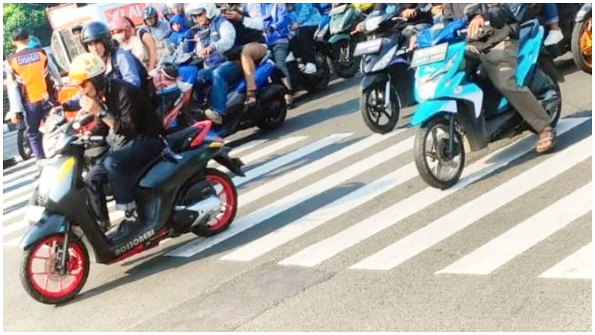 Pengendara motor mengisap rokok elektrik saat melintasi Jalan Margonda Kota Depok. Perokok sambil berkendara bakal ditindak tegas.