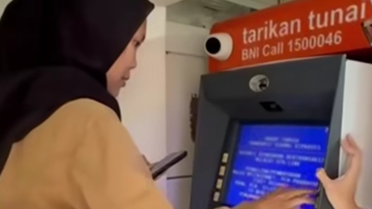 Ilustrasi penarikan dana bansos di mesin ATM.