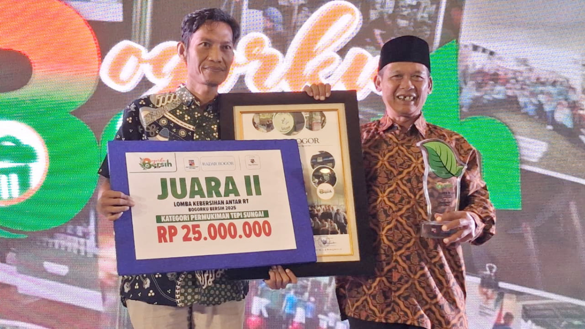 Ketua RT 05 RW 05, Kampung Warung Bandrek, Kelurahan Bondongan, Kecamatan Bogor Selatan saat menerima piagam penghargaan dalam perlombaan Bogorku Bersih 2025 kategori Pemukiman Tepi Sungai.