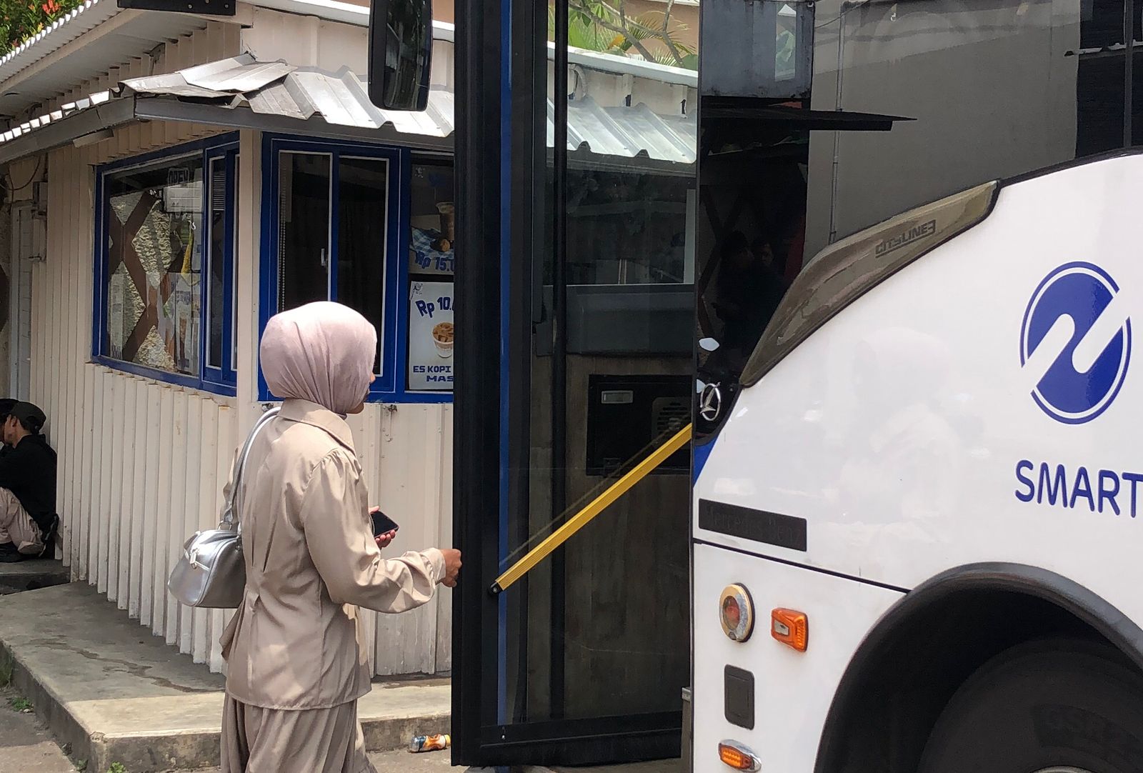 Seorang penumpang yang hendak menggunakan jasa Transjabodetabek di Halte Damri Botani Square, Kota Bogor.