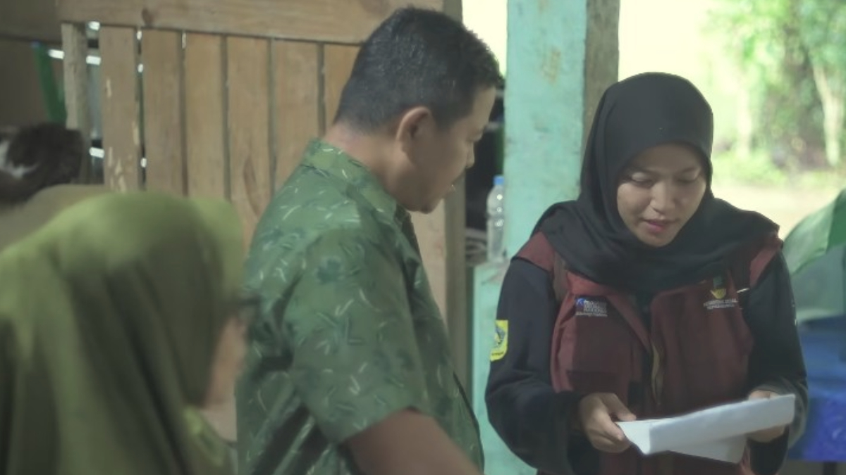 Petugas dengan teliti memeriksa data penerima Bansos.