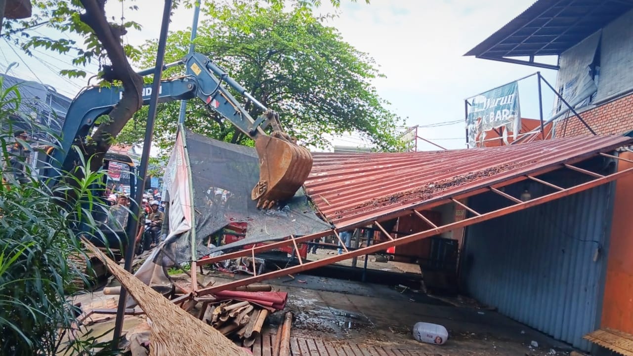 Petugas Satpol PP Kota Depok, saat melakukan pembongkaran bangunan liar (bangli) tanpa izin.