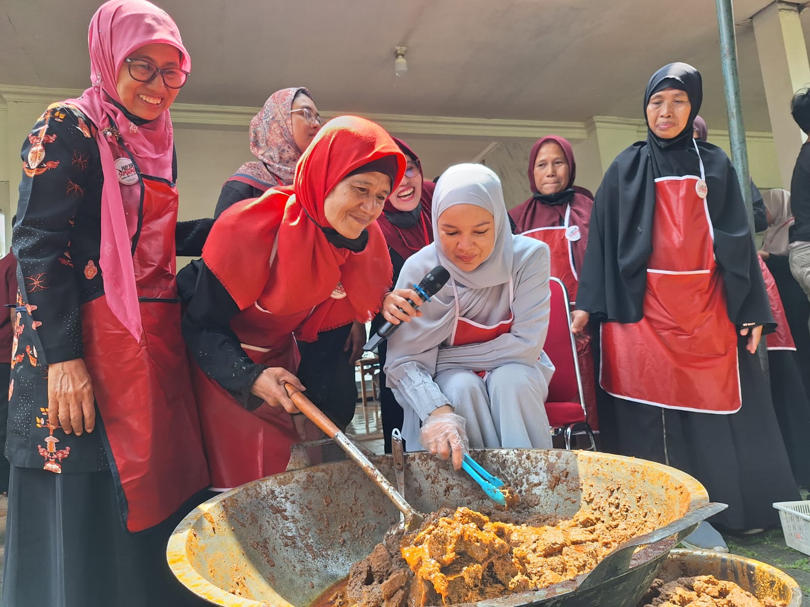 Aktris Dewi Sandra, ikut turun langsung mengaduk rendang dan menyemangati para relawan di Gedung Agribusiness and Technology Park IPB University, Minggu 7 Desember 2025.