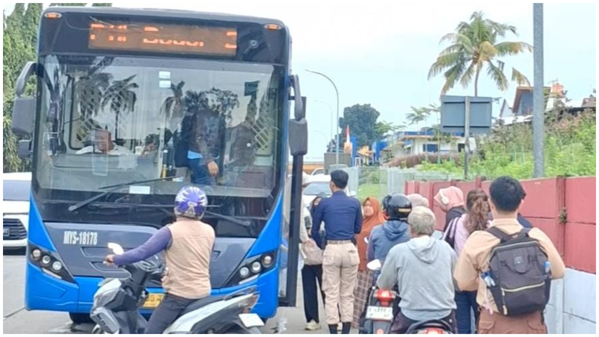 Penumpang TransJabodetabek P11 di bahu jalan Pintu Tol Citeureup saat hendak naik bus tanpa adanya halte resmi, Selasa 9 Desember 2025.