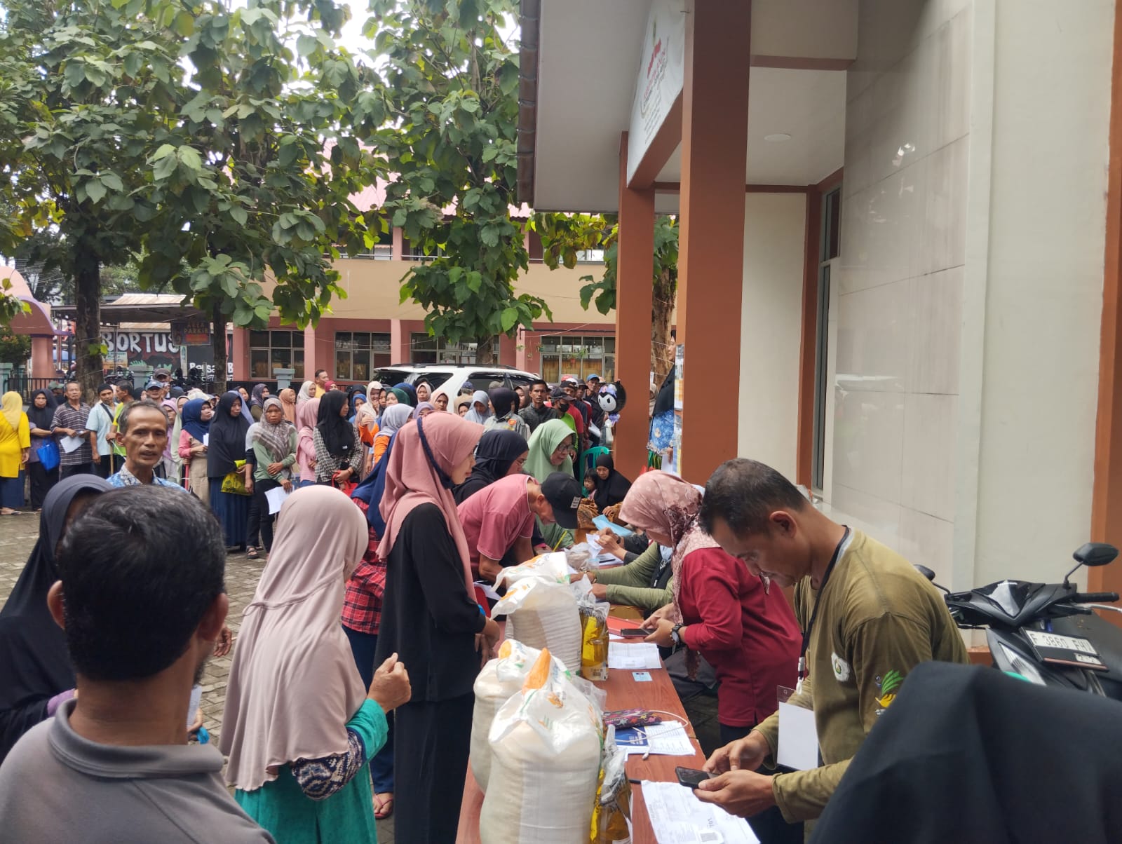 Sejumlah warga rela mengantre demi mendapatkan bantuan pangan di Kelurahan Harapan Jaya, Kecamatan Cibinong, Kabupaten Bogor.