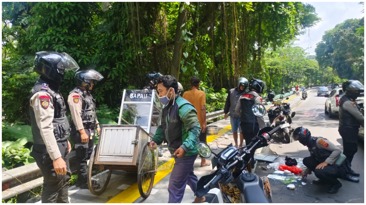 Proses evakuasi gerobak pedagang bakpau pasca ditabrak motor.