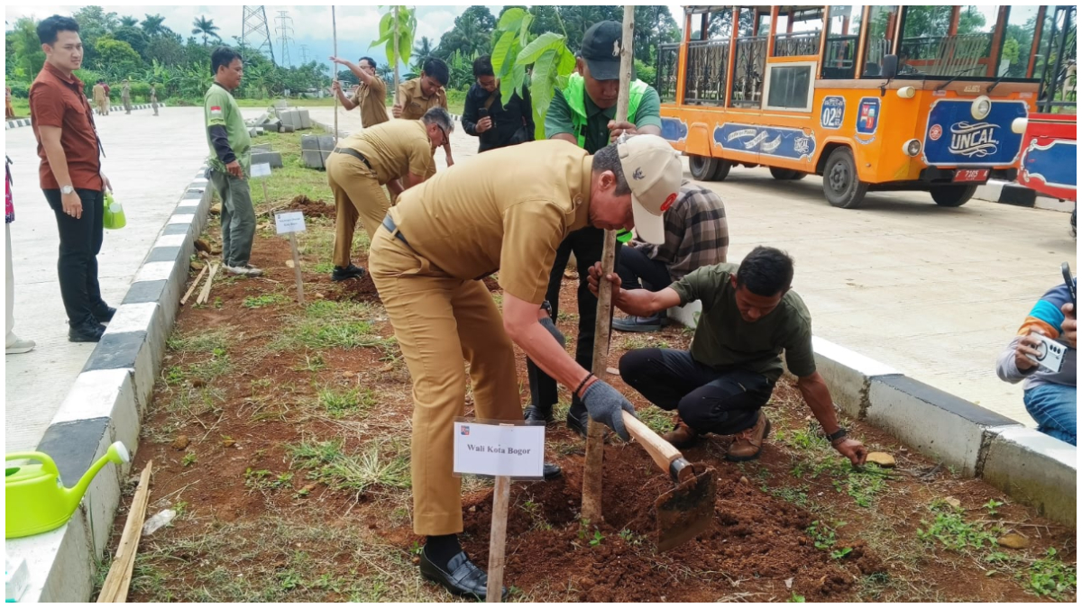Wali Kota Bogor Dedie A Rachim  menanam pohon saat meninjau Jalan R3 yang baru selesai dikerjakan.