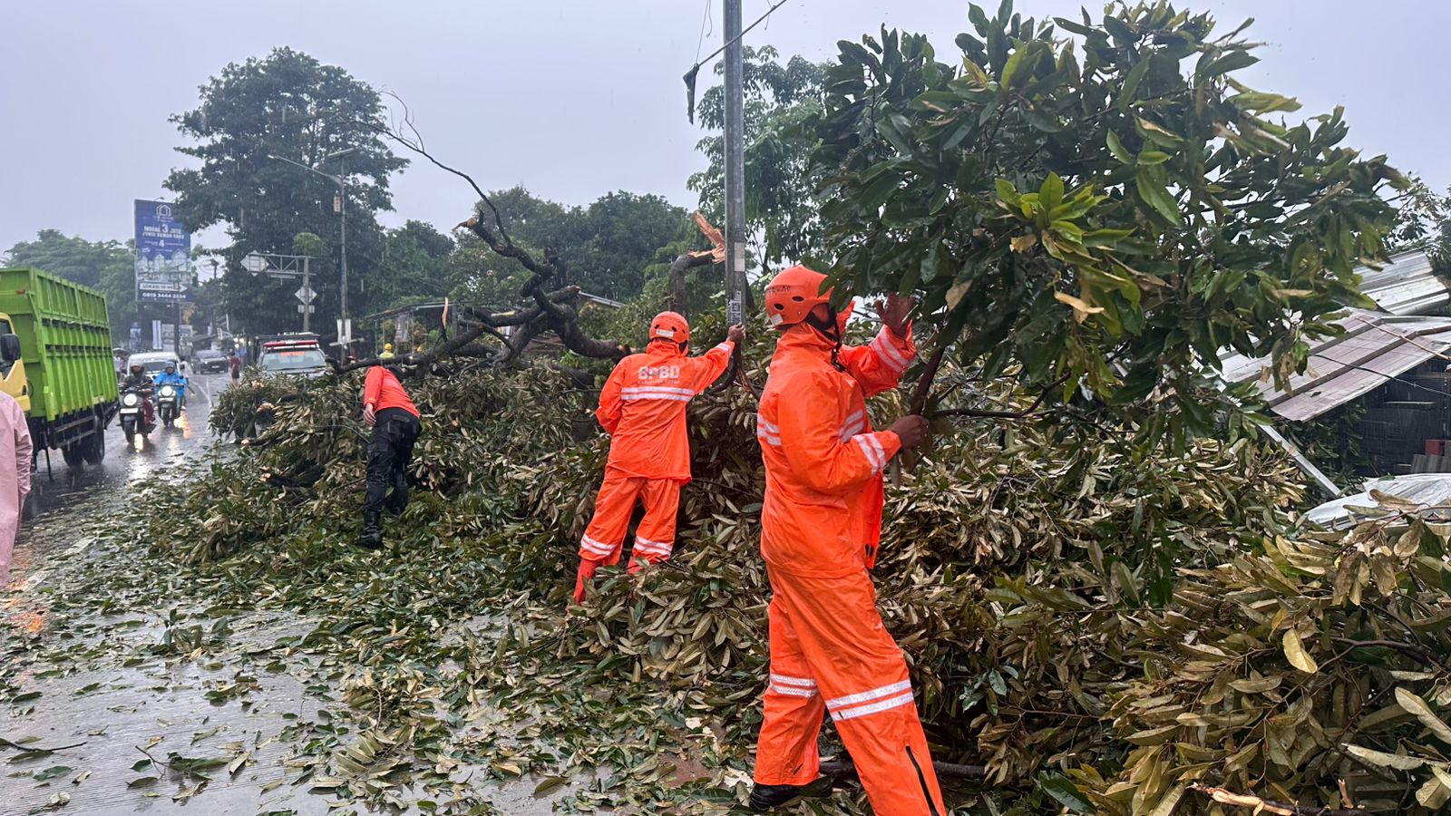 Petugas BPBD Kabupaten Bogor, tengah mengevakuasi pohon tumbang dan material pesawat terbang akibat angin puting beliung di Desa Pondok Udik, Kecamatan Kemang, Senin 29 Desember 2025.