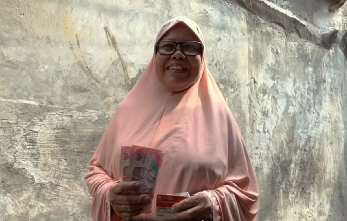 ILUSTRASI : KPM memperlihatkan uang Bansos.
