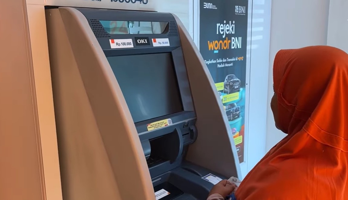 Ilustrasi KPM sedang mencairkan saldo bansos melalui KKS di ATM terdekat