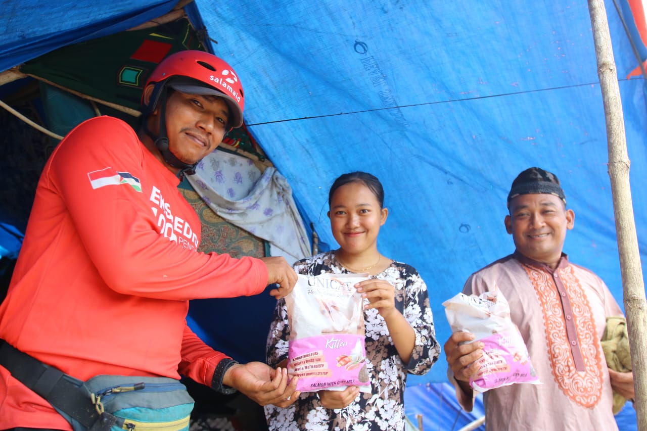 Perwakilan relawan Salamaid membagikan makanan pada anak-anak di lokasi pengungsian korban bencana banjir Aceh yang berada di Kuburan Cina.