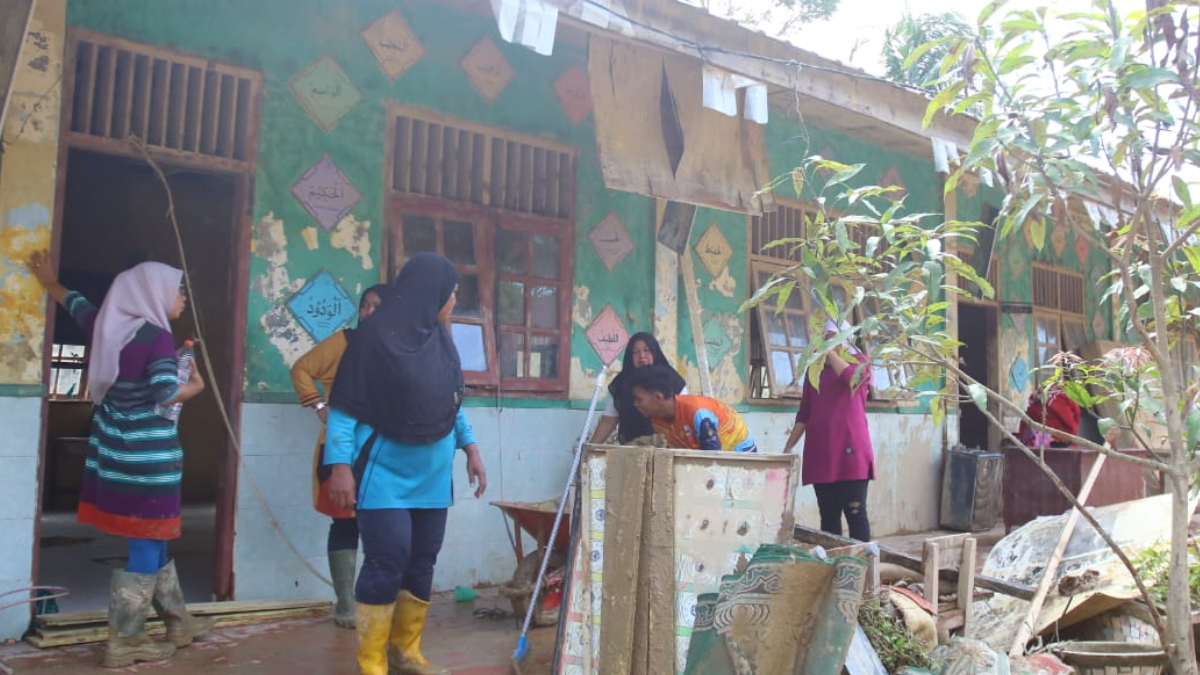 Kondisi salah satu sekolah di Kabupaten Aceh Tamiang, warga gotong royong membersihkan sisa lumpur jelang proses belajar mengajar dimulai.
