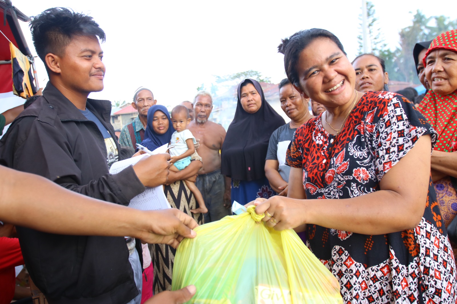 Warga Dusun Al Ikhsan, Kota Lintang Bawah, Aceh Tamiang, menerima bantuan yang diserahkan melalui koordinator berupa sembako dan uang tunai.