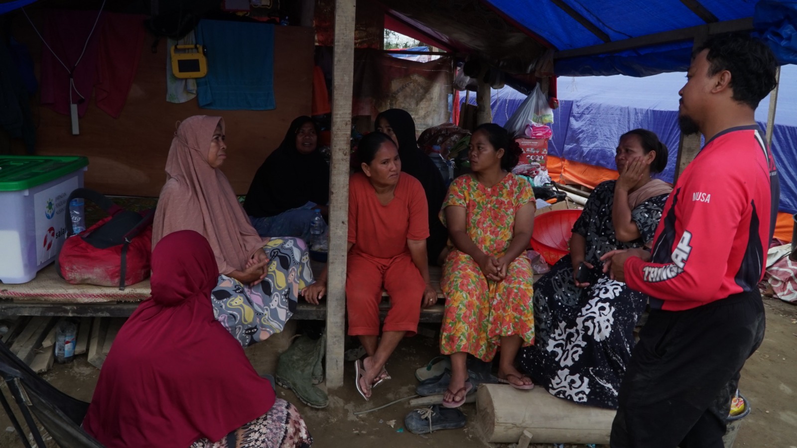 Relawan SalamAid, Muhammad Musa berbincang dengan warga Dusun Al Ikshan, Kabupaten Aceh Tamiang.