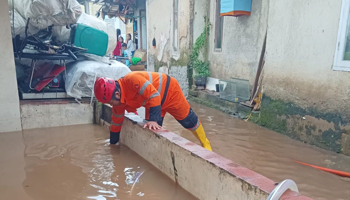 Personel BPBD Kota Bogor saat melakukan proses evakuasi warga terdampak banjir di Kelurahan Mekarwangi, Kecamatan Tanah Sareal, Jumat 9 Januari 2026.
