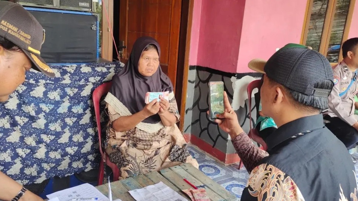 Ilustrasi penyaluran bansos kepada KPM oleh petugas