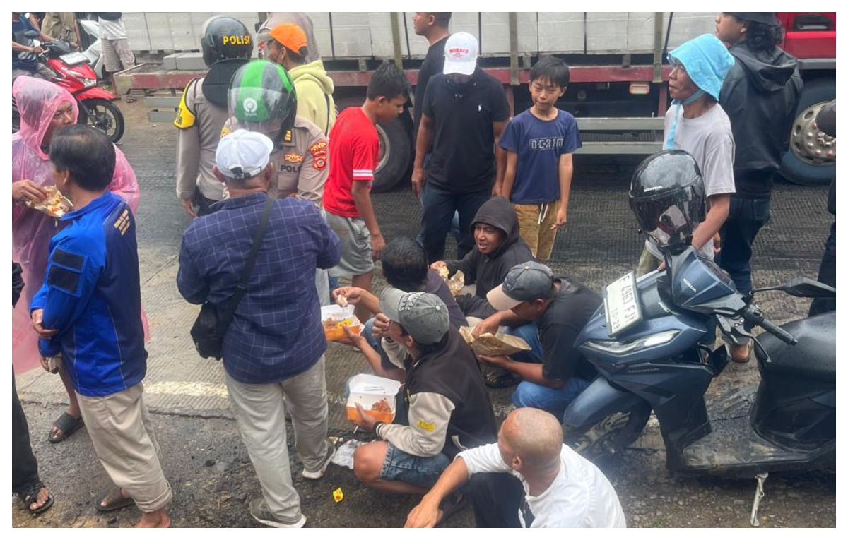 Aksi massa saat menyantap makanan yang diborong kepolisian di depan Kantor Kecamatan Cigudeg, Senin 12 Januari 2026.