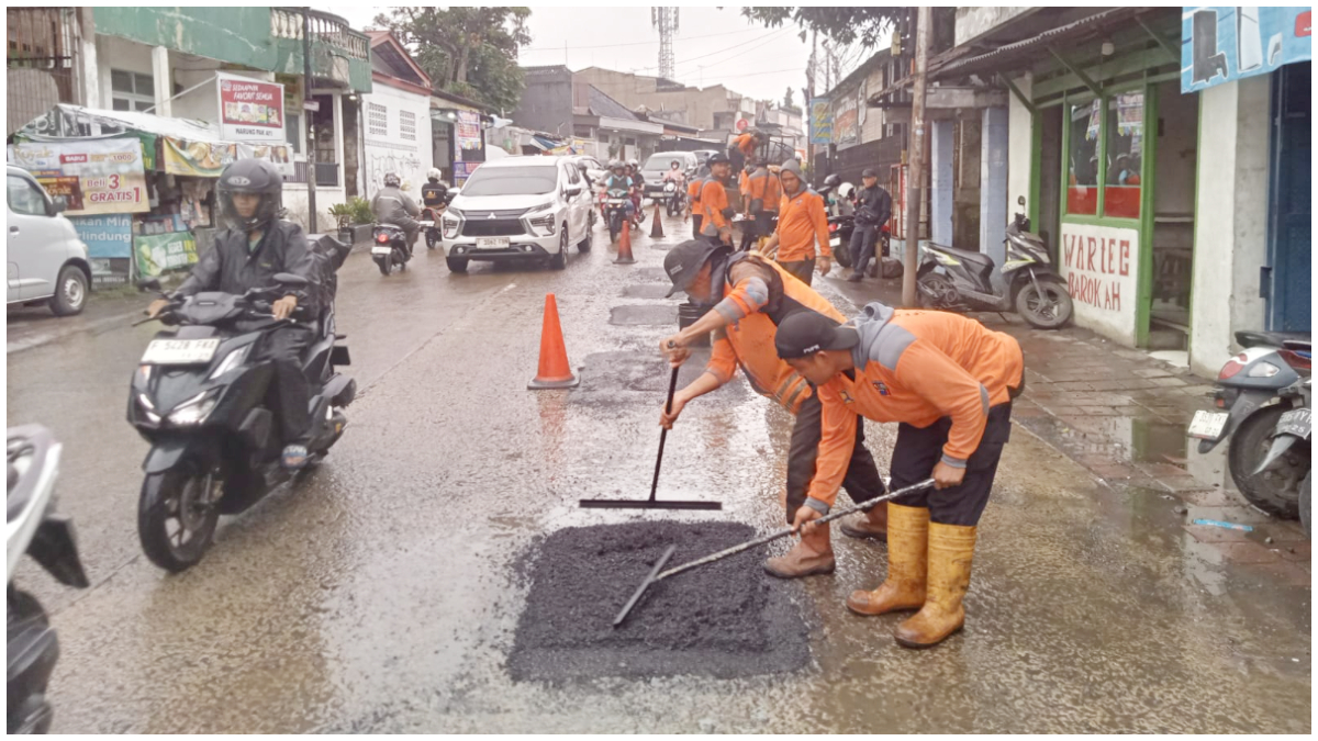 Petugas PUPD tengah memperbaiki jalan berlubang di Pulo Empang, Kecamatan Bogor Tengah, Kota Bogor,.