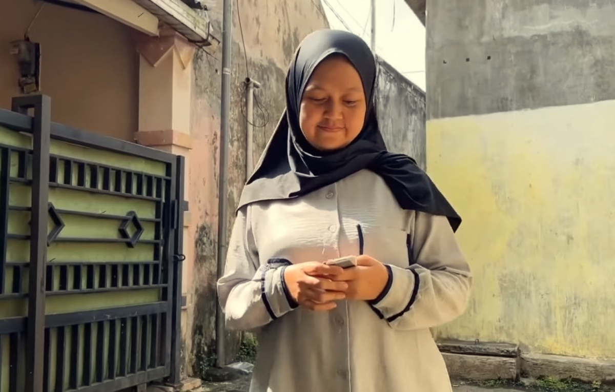 KPM membawa kartu untuk mencairkan Bansos.