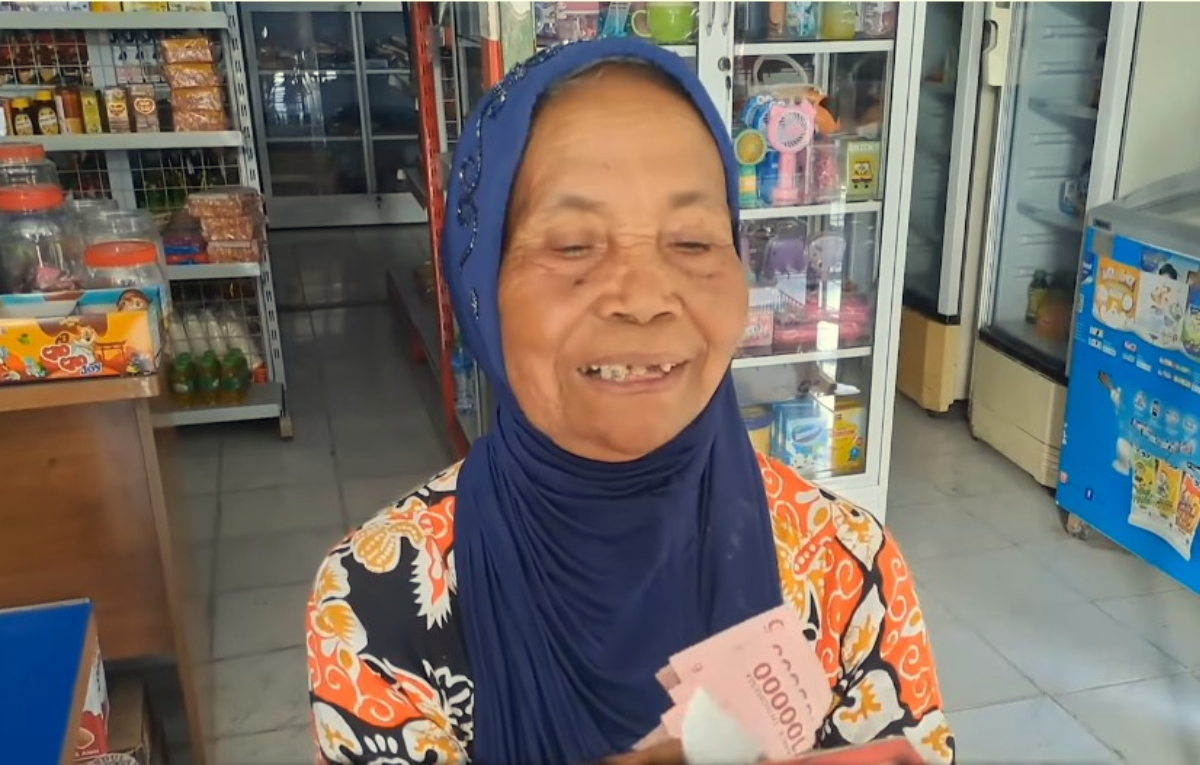 KPM memperlihatkan uang Bansos yang sudah dicairkan.