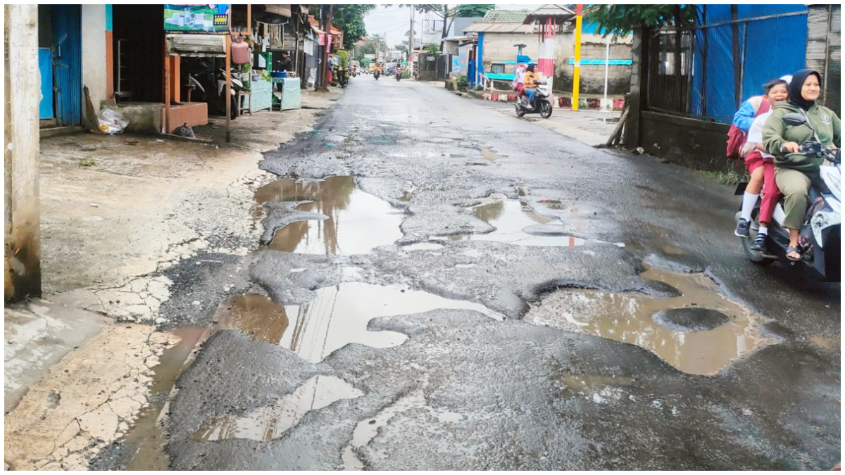 Kondisi Jalan Raya Keadilan Kota Depok yang rusak dan berlubang.