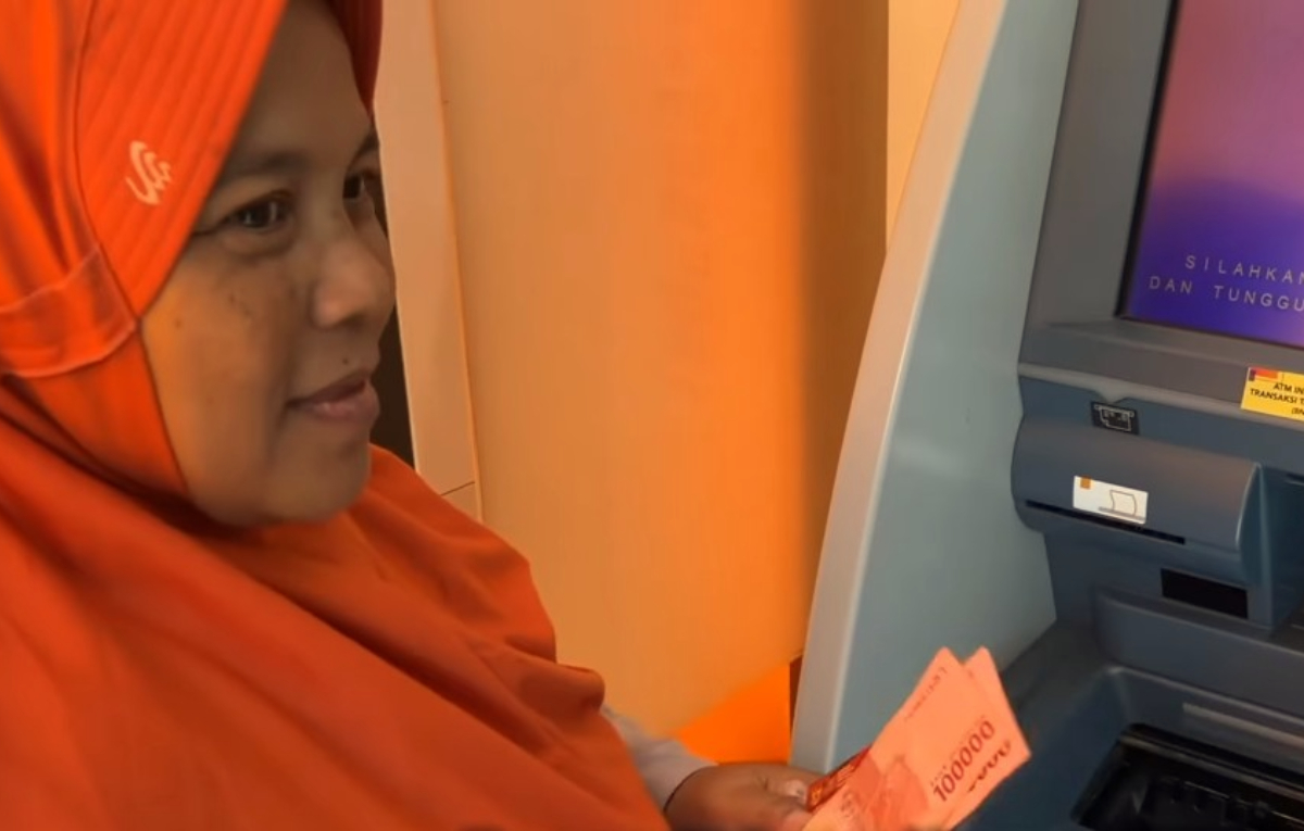 KPM sedang mencairkan dana Bansos di ATM.