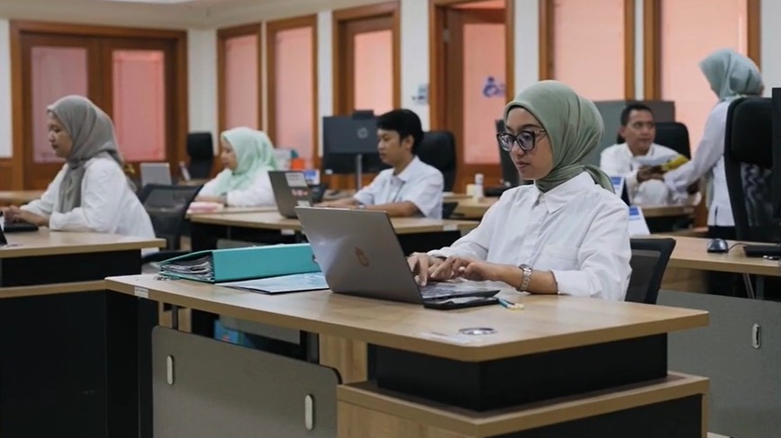Ilustrasi pendamping sosial atau petugas operator tengah memverifikasi data penerima bansos 2026