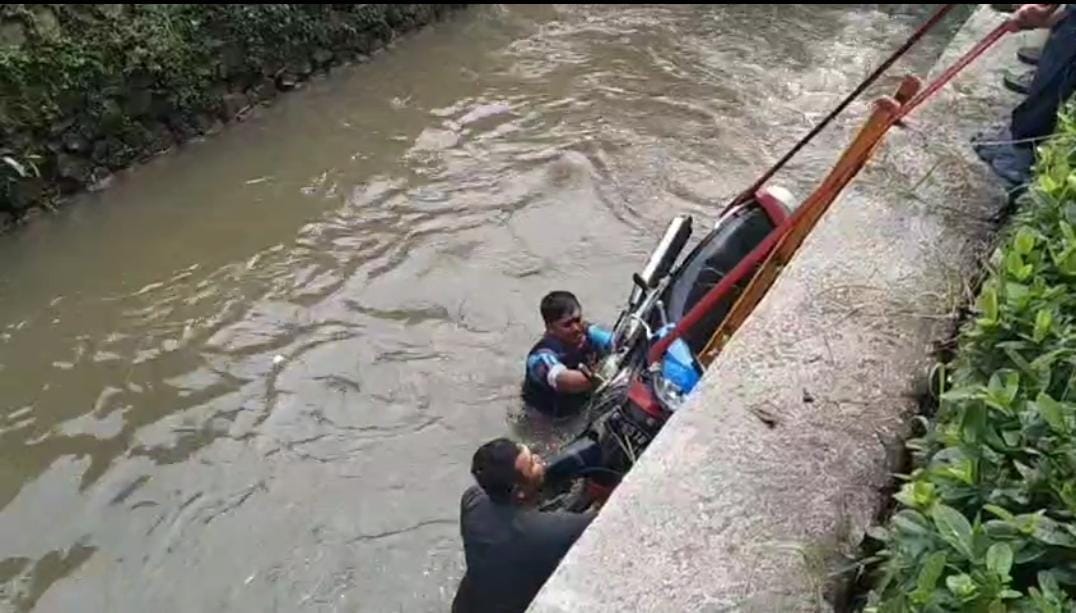Petuga pemadam kebarakaran saat mengevakuasi motor yang tercebut di Kali Metland, Kecamatan Cileungsi, Kabupaten Bogor.