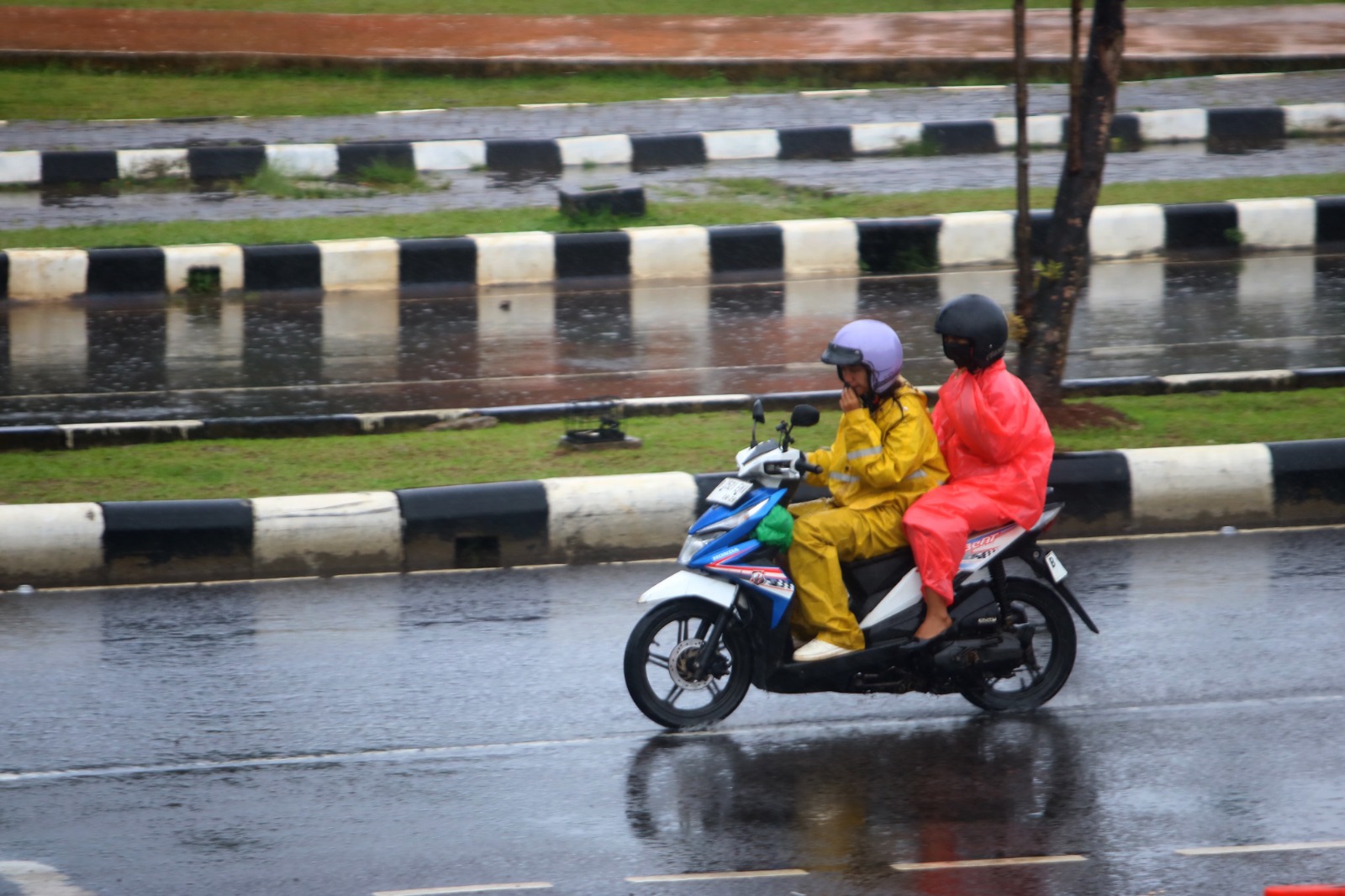 Pemotor memakai jas hujan di kawasan Pakansari, Kecamatan Cibinong, Kabupaten Bogor, akibat hujan deras.