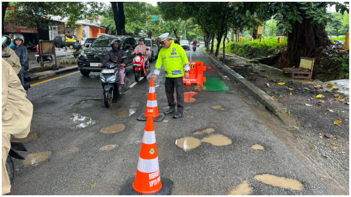 Satlantas Polres Metro Depok memasang Traffic Cone di lokasi Jalan Juanda yang rusak.