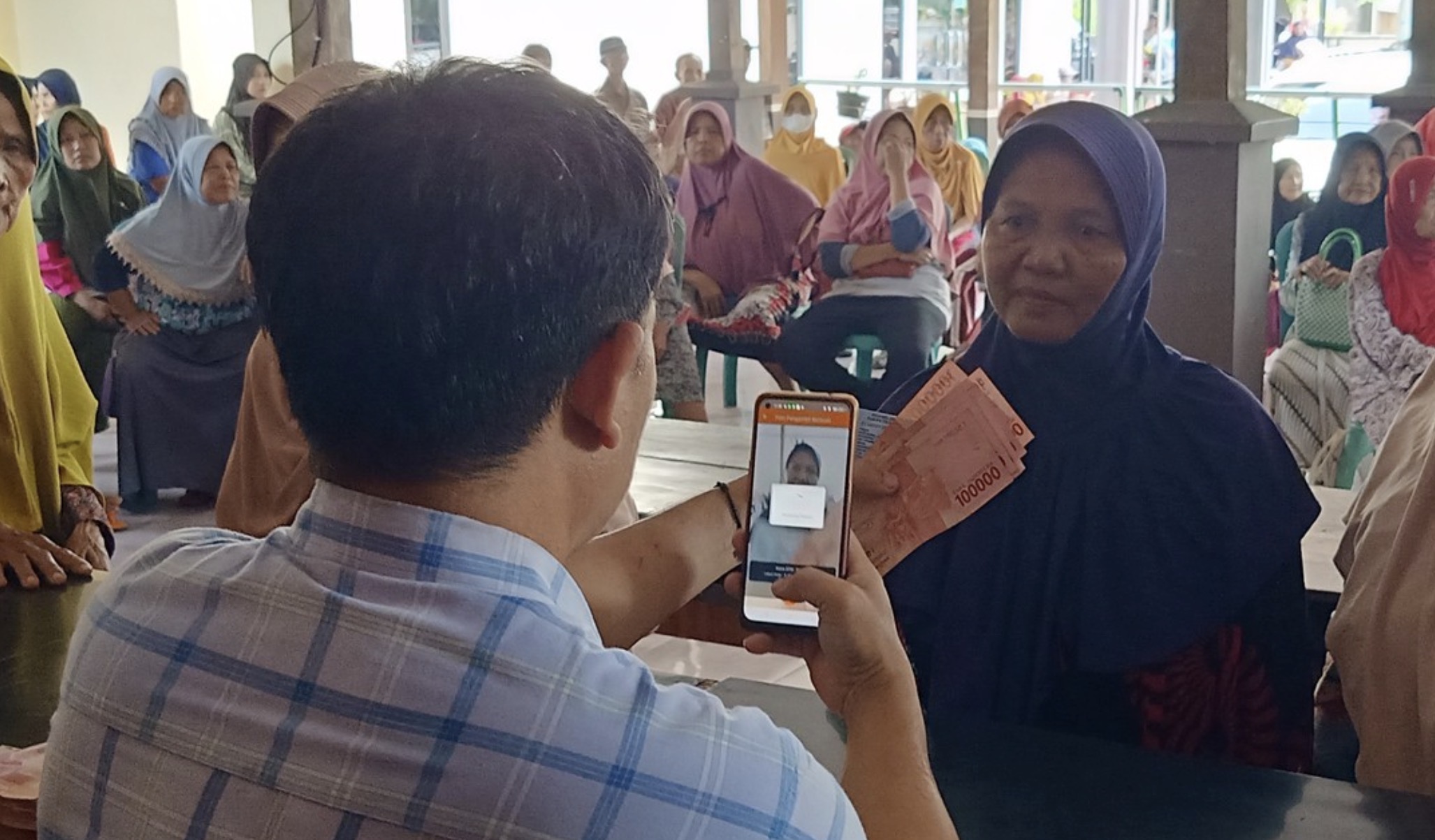 Ilustrasi pendistribusian bantuan sosial (bansos) kepada penerima manfaat.