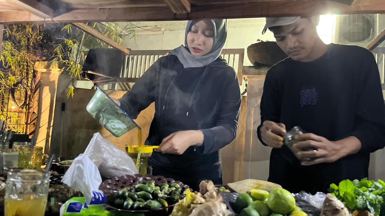 Fira, pemilik Jamu Parut, Kota Bogor, saat tengah meracik jamu.