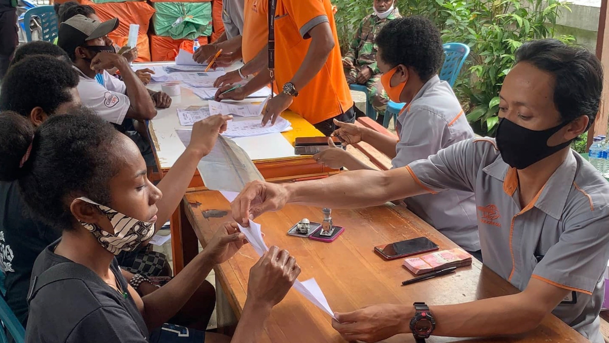 Ilustrasi petugas menyelurkan bansos kepada KPM.