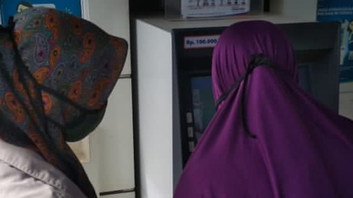 Ilustrasi KPM sedang mencairkan dana bansos di mesin ATM