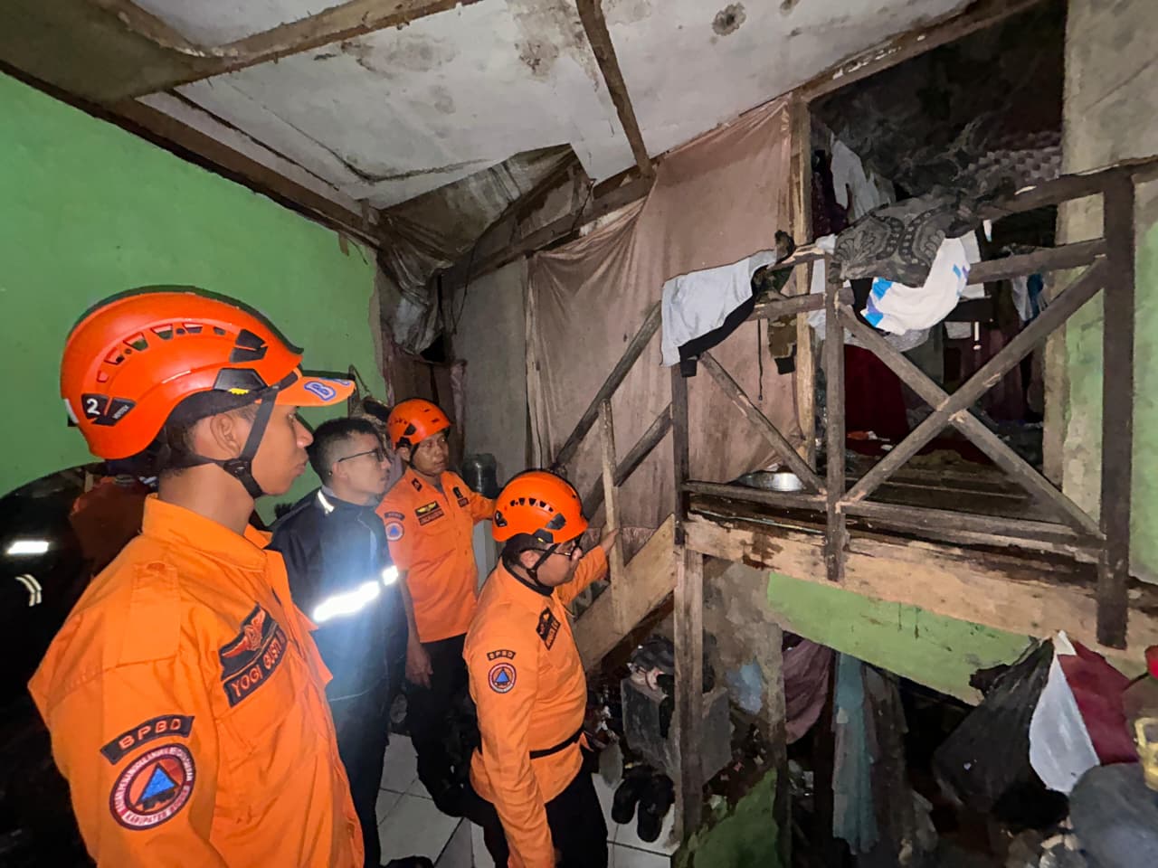 Petugas BPBD Kabupaten Bogor saat mengevakuasi rumah yang tertimpa tanah longsor di Kecamatan Megamendung, Kabupaten Bogor.